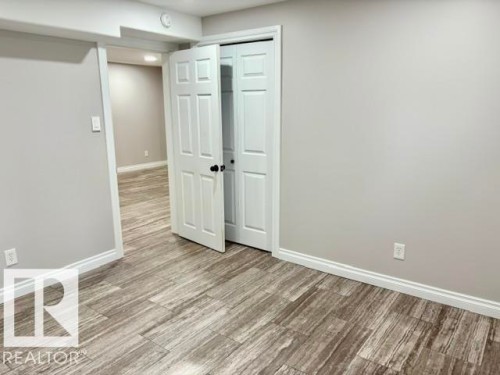 Wood-finish flooring throughout, complemented by light gray walls and white trim - 5133 45A Avenue, Vegreville, AB 