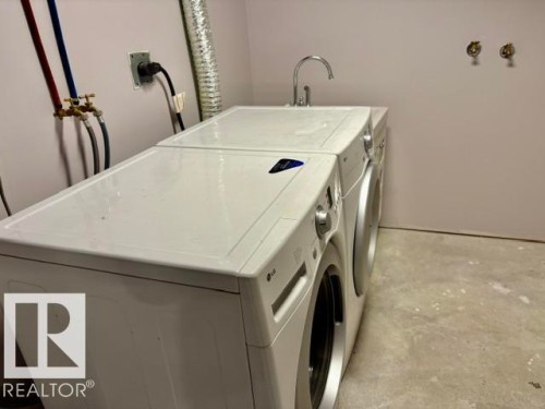 Laundry area with concrete flooring, utility sink, and wall-mounted faucet - 5133 45A Avenue, Vegreville, AB 