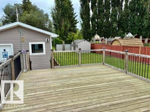 Spacious wooden deck with black baluster railing - 5133 45A Avenue, Vegreville, AB 