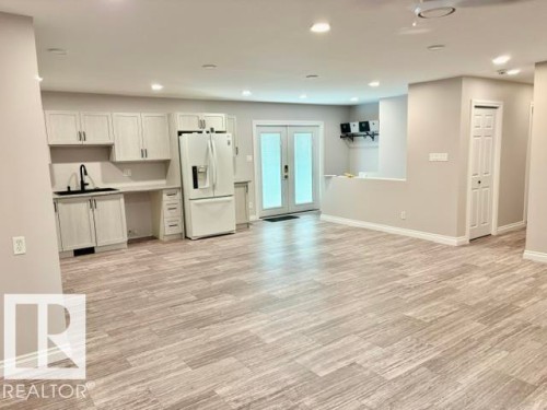 Open-concept living space featuring wood-finish flooring, recessed lighting, and light-toned walls - 5133 45A Avenue, Vegreville, AB 