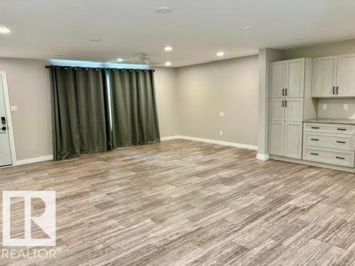 Wood-finish flooring, recessed lighting, ceiling fan, built-in cabinetry, and neutral wall tones - 5133 45A Avenue, Vegreville, AB 