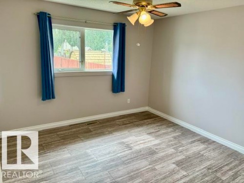Tile flooring, white trim, light neutral wall paint, and a ceiling fan with integrated lighting - 5133 45A Avenue, Vegreville, AB 