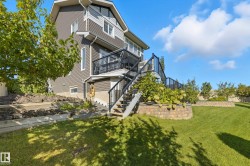 Expansive backyard with a multi-level deck, dark siding, and a gabled roofline - 
