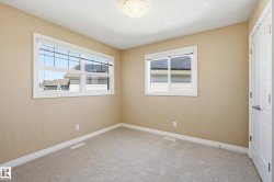 Carpeted room with neutral-toned walls, white trim, and two windows - 