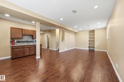 Spacious lower-level area featuring wood-finish flooring, recessed lighting, and neutral wall tones - 