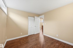 Room featuring wood-finish flooring, neutral wall paint, and white trim - 