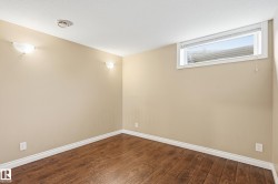 Room featuring wood-finish flooring, neutral-toned walls, and white baseboards - 