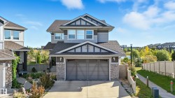 Contemporary two-story residence featuring a two-car garage, stone veneer accents, and a gabled roofline - 