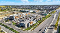 Commercial complex with multiple retail and office buildings, extensive paved parking, and direct frontage on a multi-lane thoroughfare - 