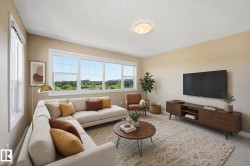 Spacious living area featuring large windows, neutral-toned walls, and a recessed ceiling light - 