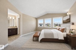 Vaulted ceiling room with three large windows, carpet flooring, and a broad entry to a bathroom featuring a double vanity with dark wood cabinetry, a light-toned countertop, and tiled flooring - 