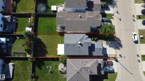 Gabled roofline, light gray shingle roofing, paved driveway, mature trees, manicured lawn - 3525 22 St Nw, Edmonton, AB 