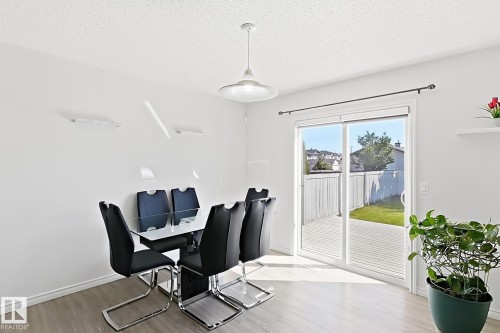 Sliding glass door leading to a wood-finish deck and fenced yard - 3525 22 St Nw, Edmonton, AB 