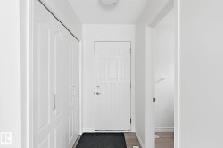 Entryway featuring a paneled door, wood-finish flooring, and built-in bi-fold closet doors with brushed nickel hardware - 