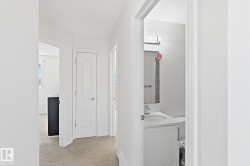 Bathroom featuring a single vanity with an integrated sink, polished chrome faucet, and decorative tiled wall - 