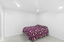 Recessed lighting, wood-finish flooring, white trim, and a white interior door - 