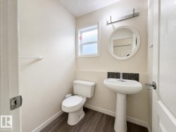Pedestal sink with mosaic tile backsplash, wood-finish flooring, and a window for natural illumination - 