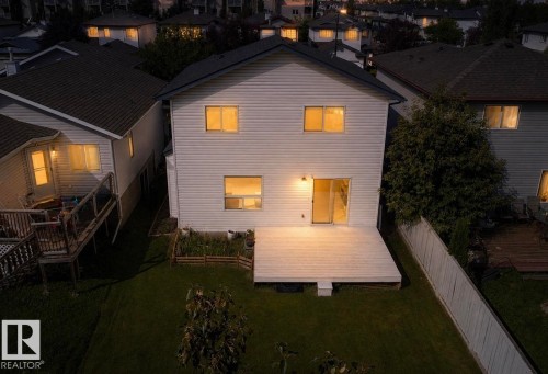 Two-story residence with a rear deck, sliding glass door, and fenced backyard - 3525 22 St Nw, Edmonton, AB 