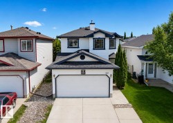 Two-story residence featuring a two-car garage with a concrete driveway and sidewalk - 