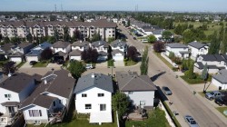 Residential area featuring detached homes with asphalt shingle roofs and private driveways - 