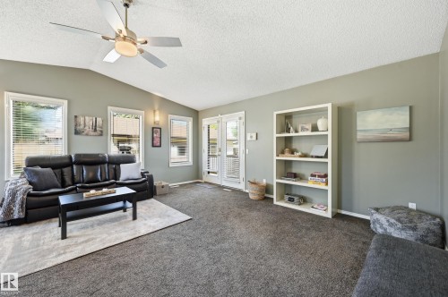 Vaulted ceiling, ceiling fan with integrated lighting, multiple windows with blinds, built-in shelving, and carpeted flooring - 10552 45 Street Nw, Edmonton, AB 