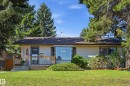 Single-story residence featuring light-colored siding, a dark shingle roof, and a bay window - 10552 45 Street Nw, Edmonton, AB 