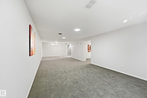 Recessed lighting, wall-mounted air conditioning unit, gray carpeting, and white painted walls - 10552 45 Street Nw, Edmonton, AB 