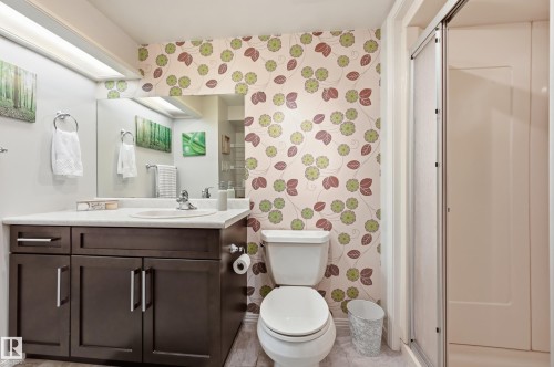 Dark wood-finish vanity with a white countertop and integrated sink - 10552 45 Street Nw, Edmonton, AB 