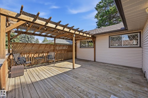 Expansive wood deck with a built-in pergola, lattice privacy screens, and decorative window grilles - 10552 45 Street Nw, Edmonton, AB 