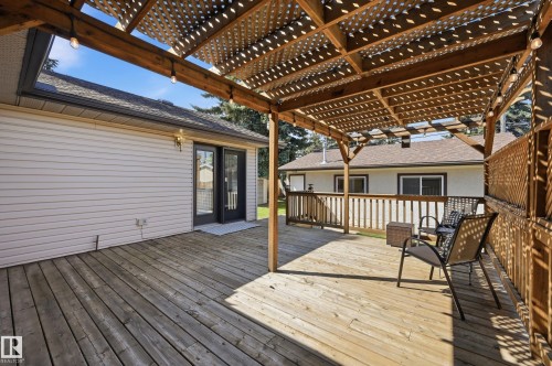 Wood-finish deck with a lattice pergola, dual pane French doors, and exterior lighting - 10552 45 Street Nw, Edmonton, AB 