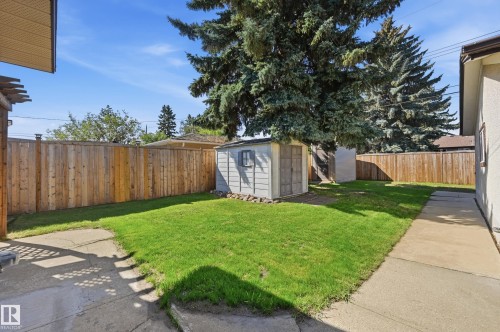 Manicured lawn, wood fencing, concrete pathways, and a storage shed - 10552 45 Street Nw, Edmonton, AB 