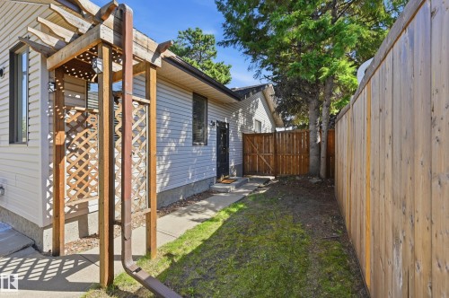 Wood pergola structure, lattice detailing, concrete pathway, wood-plank fencing, and mature trees - 10552 45 Street Nw, Edmonton, AB 