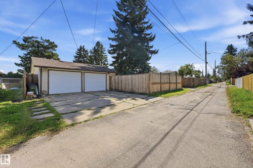 Detached two-car garage with white overhead doors, shingle roof, and concrete driveway - 10552 45 Street Nw, Edmonton, AB 