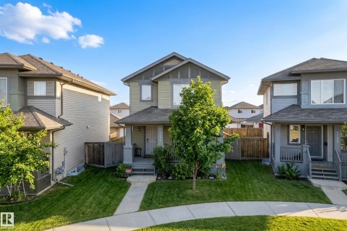 Two-story residence featuring a covered front porch, siding exterior, and a mature front yard tree - 1148 35 Avenue Nw, Edmonton, AB 