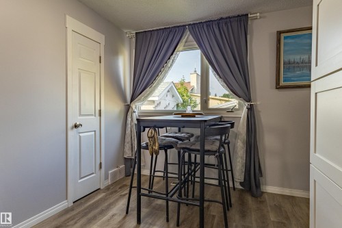 Wood-finish flooring, white paneled door, and a window with natural light - 7408 180 Street Nw, Edmonton, AB 