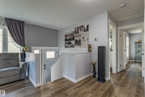 Wood-finish flooring throughout, light gray wall tones, white trim, and interior doors - 7408 180 Street Nw, Edmonton, AB 