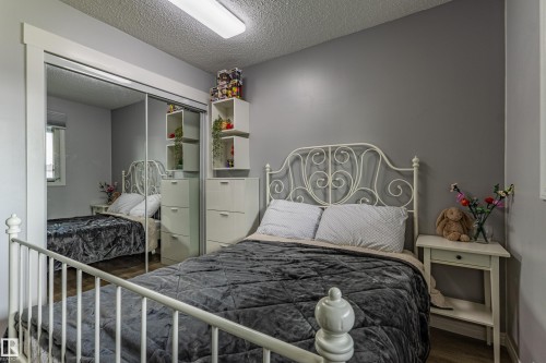 Wood-finish flooring, mirrored sliding closet doors, and neutral wall tones - 7408 180 Street Nw, Edmonton, AB 
