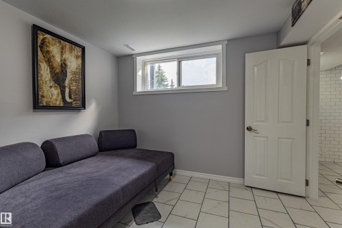 White tile flooring with linear veining, light gray painted walls, and a white interior door with paneling - 7408 180 Street Nw, Edmonton, AB 