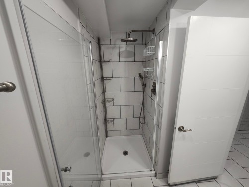 Glass-enclosed shower with white subway tile surround, rain shower head, and an additional handheld shower fixture - 7408 180 Street Nw, Edmonton, AB 