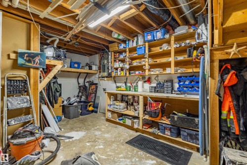 Exposed wood beam ceiling, comprehensive built-in shelving, integrated workbench, concrete flooring, and ample storage space - 7408 180 Street Nw, Edmonton, AB 
