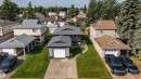 Two-story residence with a front-facing garage, a concrete driveway, a well-maintained lawn, and a paved walkway leading to the entrance - 7408 180 Street Nw, Edmonton, AB 