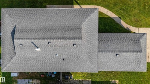 Grey shingle roofing with a prominent chimney and multiple ventilation units - 7408 180 Street Nw, Edmonton, AB 