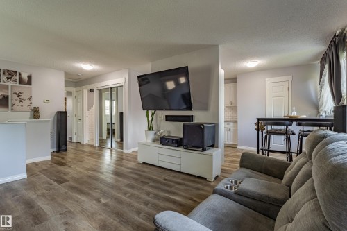 Wood-finish flooring throughout, white trim, and light gray wall tones - 7408 180 Street Nw, Edmonton, AB 