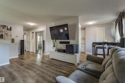 Wood-finish flooring throughout, white trim, and light gray wall tones - 