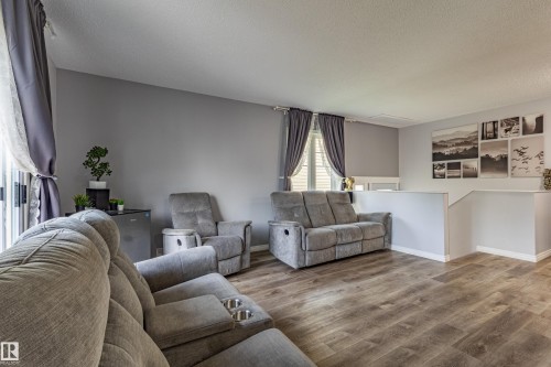 Wood-finish flooring throughout, light gray wall paint, and white trim - 7408 180 Street Nw, Edmonton, AB 