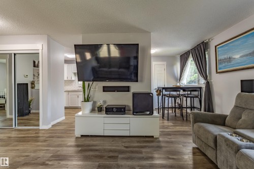 Wood-finish flooring throughout, white baseboards, and neutral wall tones - 7408 180 Street Nw, Edmonton, AB 