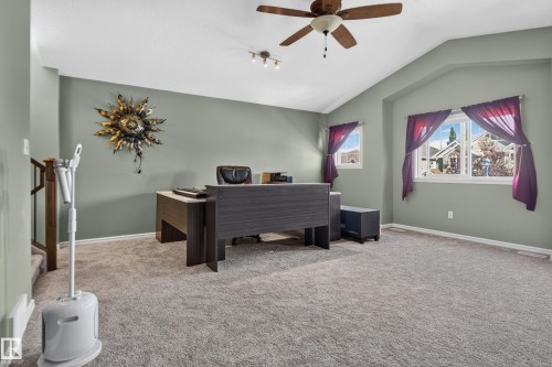 Carpeted room with vaulted ceilings, a ceiling fan, and multiple windows - 1332 72 Street Sw, Edmonton, AB 