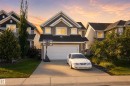 Two-story residential exterior with a front-facing garage, concrete driveway, and a landscaped front yard - 1332 72 Street Sw, Edmonton, AB 