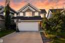 Gabled two-story exterior with horizontal siding and shingle accents, attached two-car garage, concrete driveway, and landscaped front yard - 1332 72 Street Sw, Edmonton, AB 