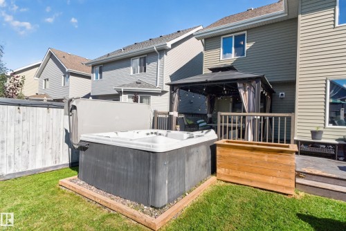 Private backyard featuring a hot tub, wooden planter box, and a covered gazebo - 1332 72 Street Sw, Edmonton, AB 